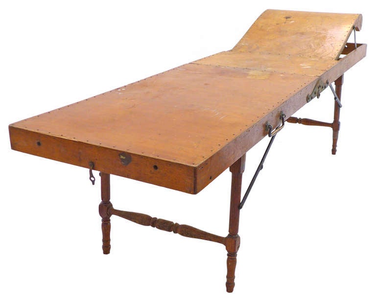 An interesting Gleason Sanitary Couch, or cooling table, originally used for funeral viewing.  Assembled of wood, brass brads and ornamental iron hardware.  The piece is completely foldable and portable.  An alluring example of late-Victorian