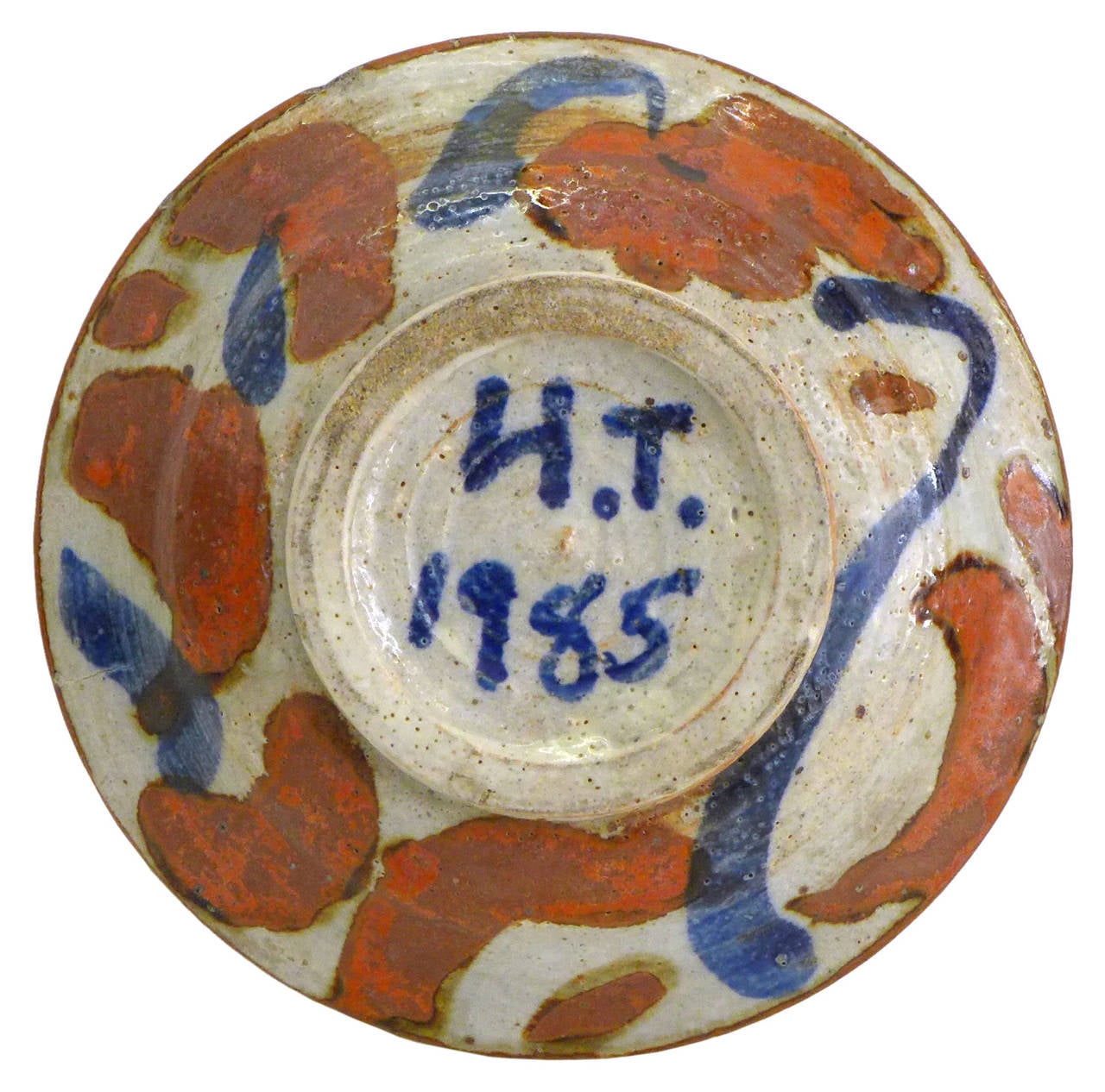 A beautiful, small ceramic dish by noted Southern California ceramicist Henry Takemoto.  A simple, organic motif of primitively stylized land and water wonderfully executed in rich yet muted tones.  Item is signed and dated underneath:  