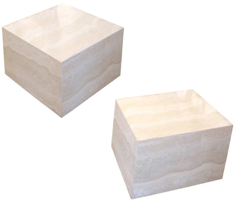 A wonderful and unusual pair of low side tables in a beautiful, figured travertine.  Mitred travertine slabs forming subtly surreal, askew cubes. Great scale and sophistication with a fun decorative presence. Items stamped, 