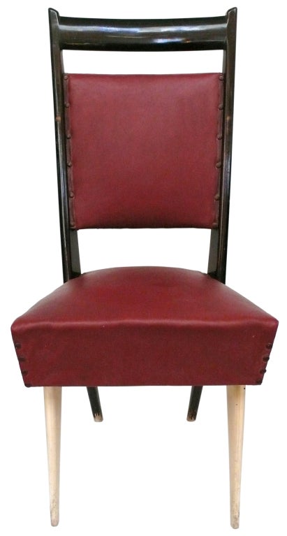 Unusual set of sculptural Italian dining chairs. Original, two-tone lacquered wooden frames and maroon leatherette with beautiful brass construction lugs and upholstery tacks. A great set of mid-century Italian seating.