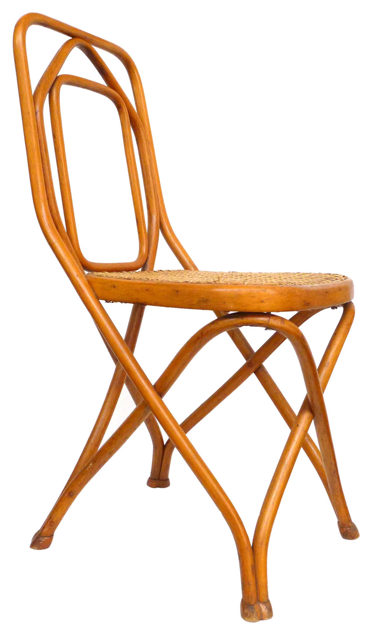 An exceptionally rare and exquisite set of 4 chairs by Thonet.  Classic Thonet materials of bentwood and woven cane in an elegant, unusual variation on the more typically-seen Thonet forms:  softly geometric, concentric loops at the back continuing