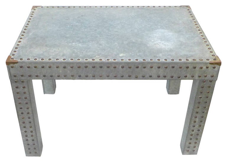 An unusual, studded side table clad in galvanized steel.  Trimmed with parrallel rows of copper-plate riviets and finished with complimentary copper-plate corner ornaments.  An undeniably Parsons-Table inspired piece.  A simple, masculine decorative
