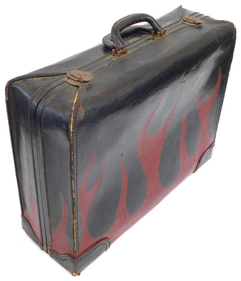 A wonderful folk-art, hand-painted vintage leather suitcase. Stylized red painted flames adorn this black leather suitcase on all four sides. Part Hot Rod . . . part Rock & Roll. A wonderfully unusual piece of Americana, dying to make an appearance