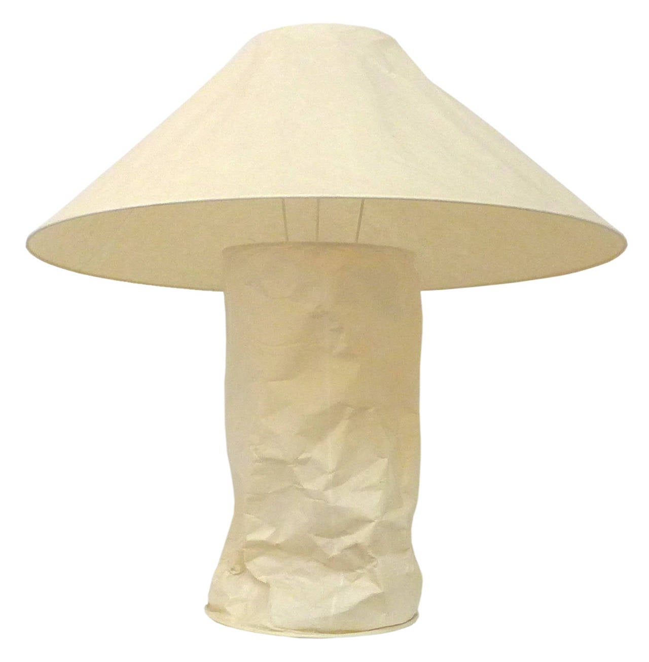 The unique and beautiful Lampampe table lamp by Ingo Maurer. Created for his eponymous company in 1980, this imaginative table-lamp-as-light-sculpture wears an exterior of intentionally wrinkled Japanese paper, emitting a gentle diffused light