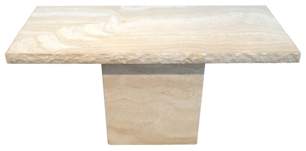 A fantastic and massive travertine console table with a beautiful, rough-hewn edge detail. A wonderfully simple and powerful table, just begging for a special pair of lamps.
