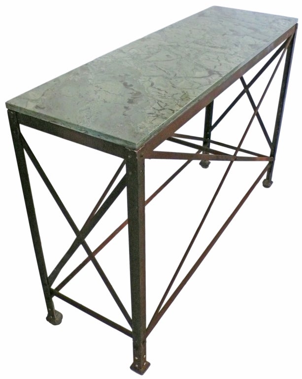 A wonderful and early 20th century, steel console table with a spectacular green, figured-granite top. A strong, dramatic form with four X-braces and a dark, beautiful patina. An extraordinary console table with a powerful decorative presence.