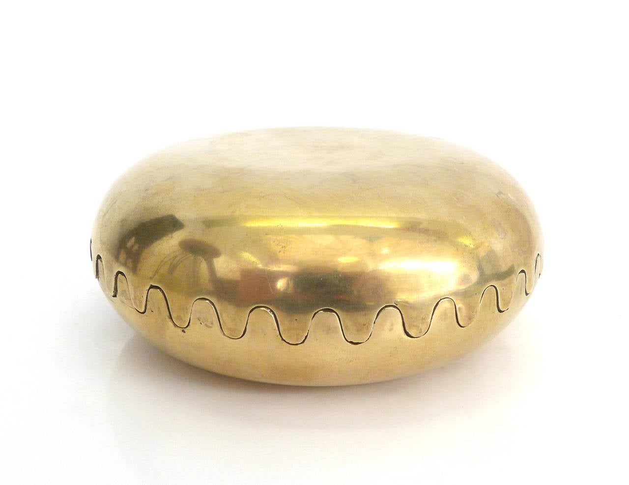A lovely box of two identical cast brass halves with sinusoid lips joining to form a squished-sphere.  An elegant and unexpectedly creaturely decorative object.