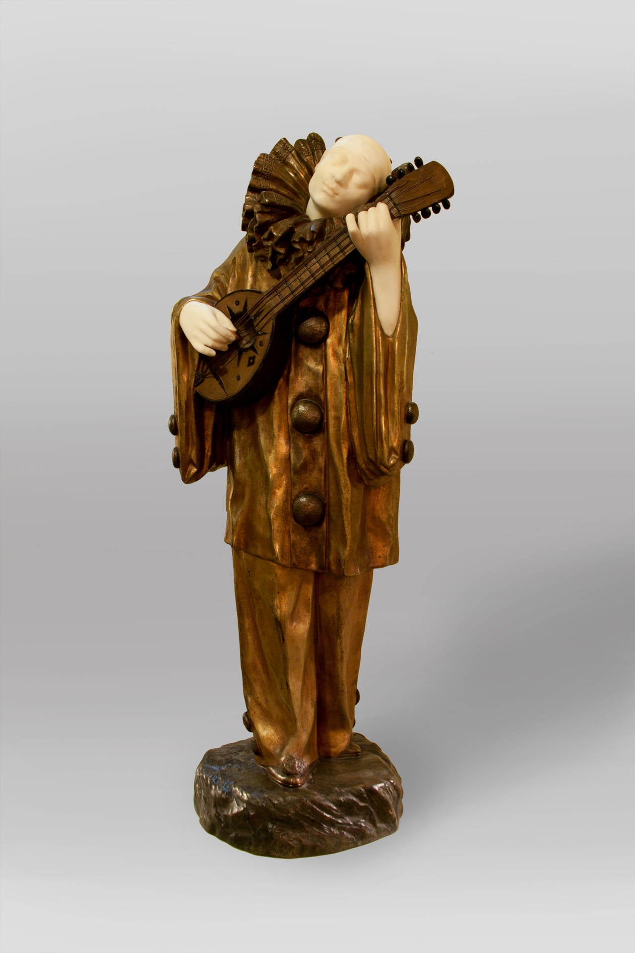 A rare sculpture in gilt bronze, with marble bust and hands, of a clown playing a guitar by French sculptor Demetre Chiparus, signed.