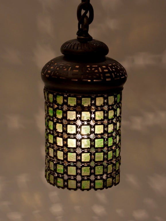 A Tiffany Studios glass and bronze chainmail lantern with reticulated cap in the Moorish taste.