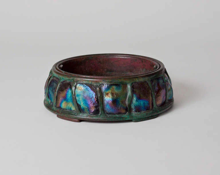 This bronze planter by Tiffany Studios features a row of Tiffany Favrile Glass Turtle Back Tiles with an iridescent blue, green, and purple finish, and is signed.