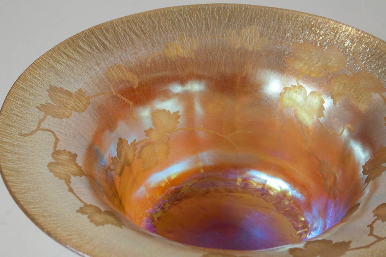 A Tiffany Studios Favrile Glass gold iridescent bowl with carved leaf and vine decoration to the interior, signed.