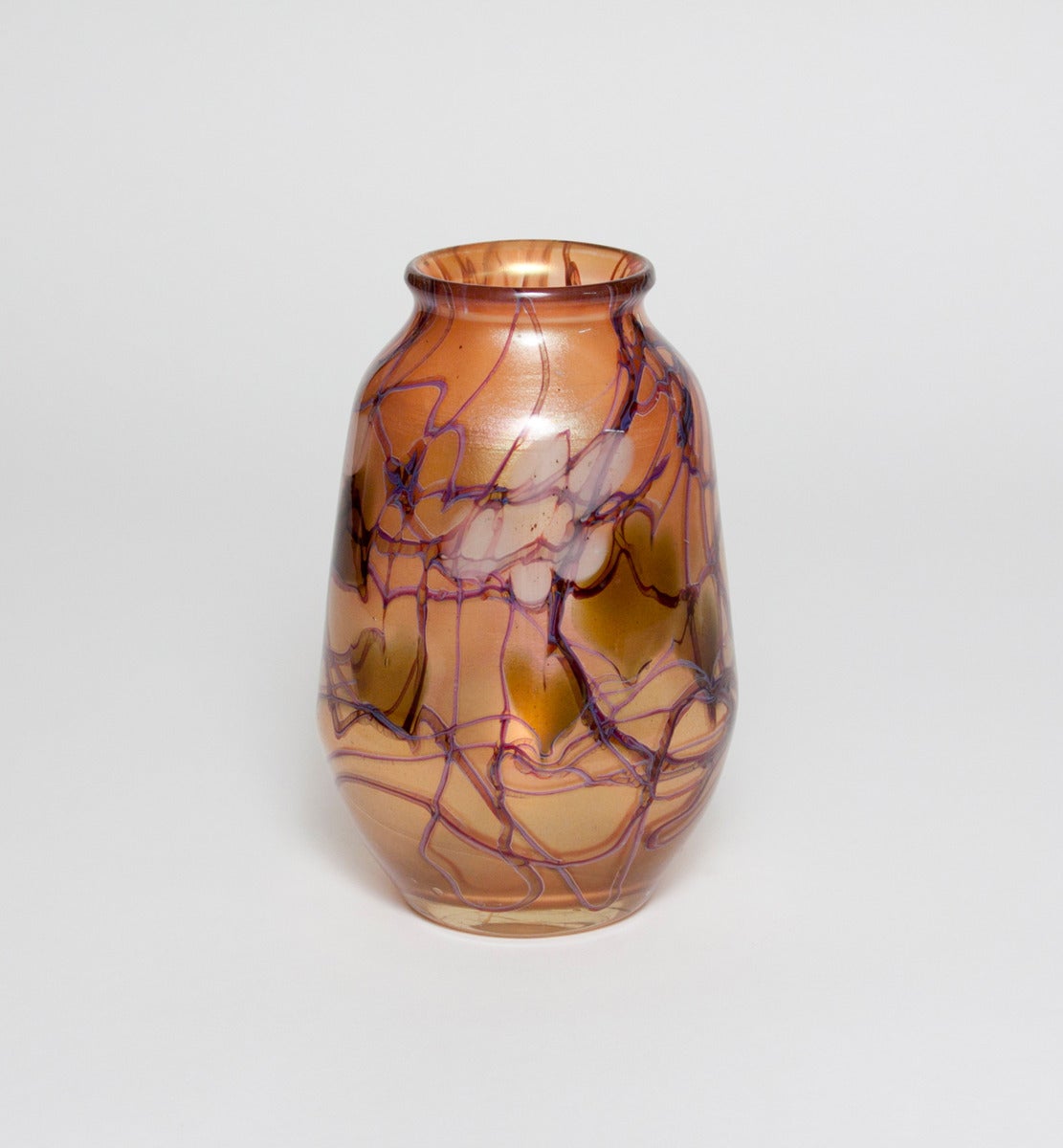 This Tiffany Studios Favrile Glass Paperweight Vase features an allover decoration of white flowers amidst swirling leaves and vines and is signed.