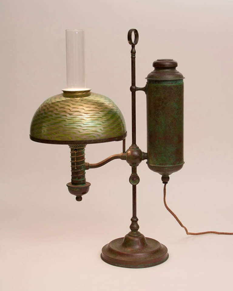 A Tiffany Studios single-student lamp with a bronze base and favrile glass damascene shade, signed.