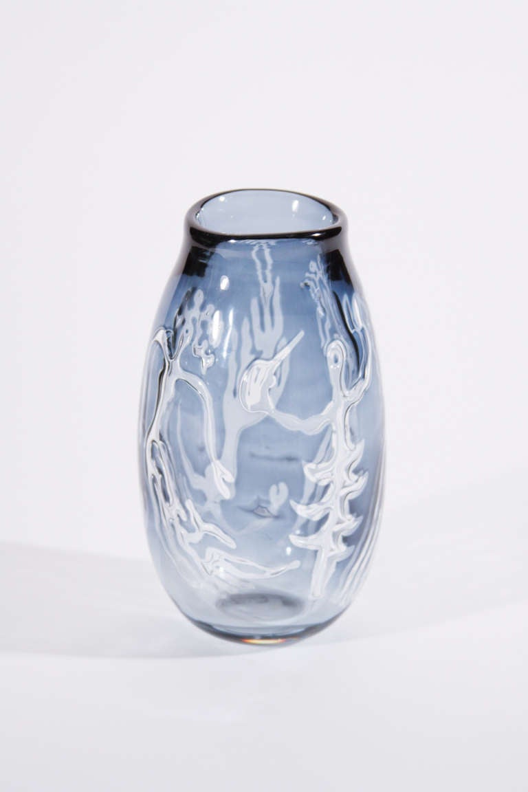 A rare Orrefors 'Ariel' glass vase from 'Water Games' series, the elongated form with irregular rim in clear and blue glass surrounding anthropomorphic figures, designed by Edvin Ohrstrom, signed and with date code.