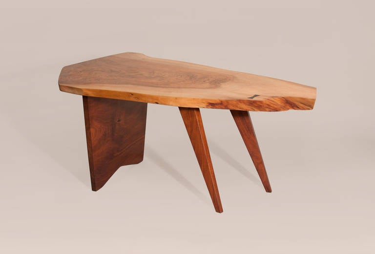 A low table by George Nakashima, the top in English Walnut with a Black Walnut base, commissioned by a Long Island family in 1960, with client's name on the underside.  Comes with original paperwork from Nakashima Studio.