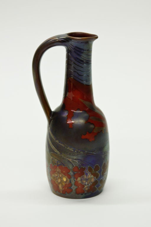 Zsolnay ewer with stylized landscape design and a radiant sunrise, glazed in an iridescent purple, blue and red, signed.