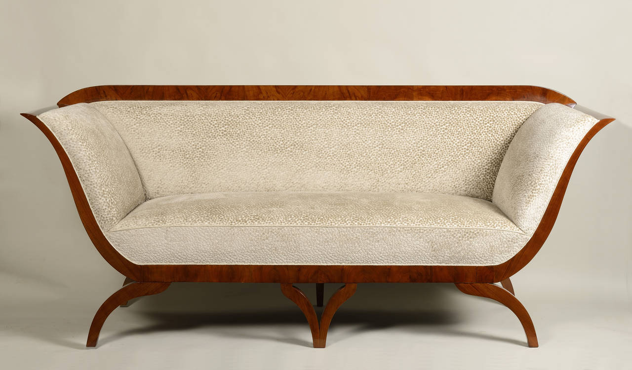 An important and iconic Biedermeier sofa in walnut attributed to the father of the style. Upholstered in fabric by Kravet.