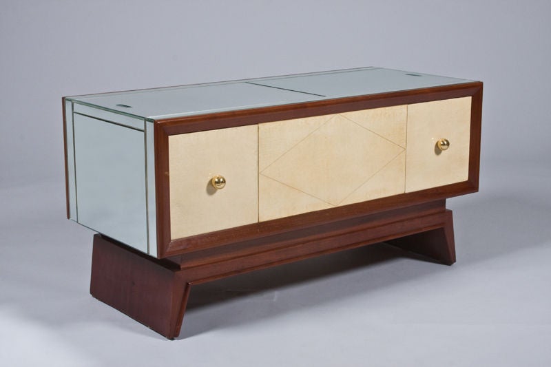 An unusual mirrored coffee table or cabinet by Maurice Champion. Solid mahogany with parchment drawers on front and reverse with bronze pulls.