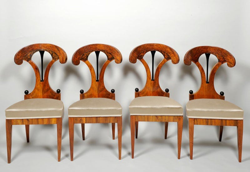 A set of four outstanding Biedermeier side chairs in vivid walnut veneer with with single ebonized splat and ink painted detailing.