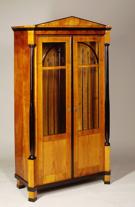 A petite Biedermeier bookcase.

Bookmatched cherry veneer with tapered columns with ebonized detailing,

Austria, circa 1820-1830.