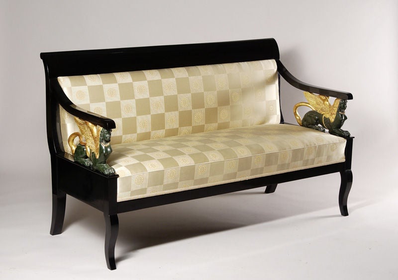 An exceptional Empire sofa

Austere and opulent, ebonized pear wood with gilt and polychrome carved mounts. Winged Sphinx arm supports and stylized cabriole legs. Please see our coordinating Empire armchair to complete the suite.

Fabric by
