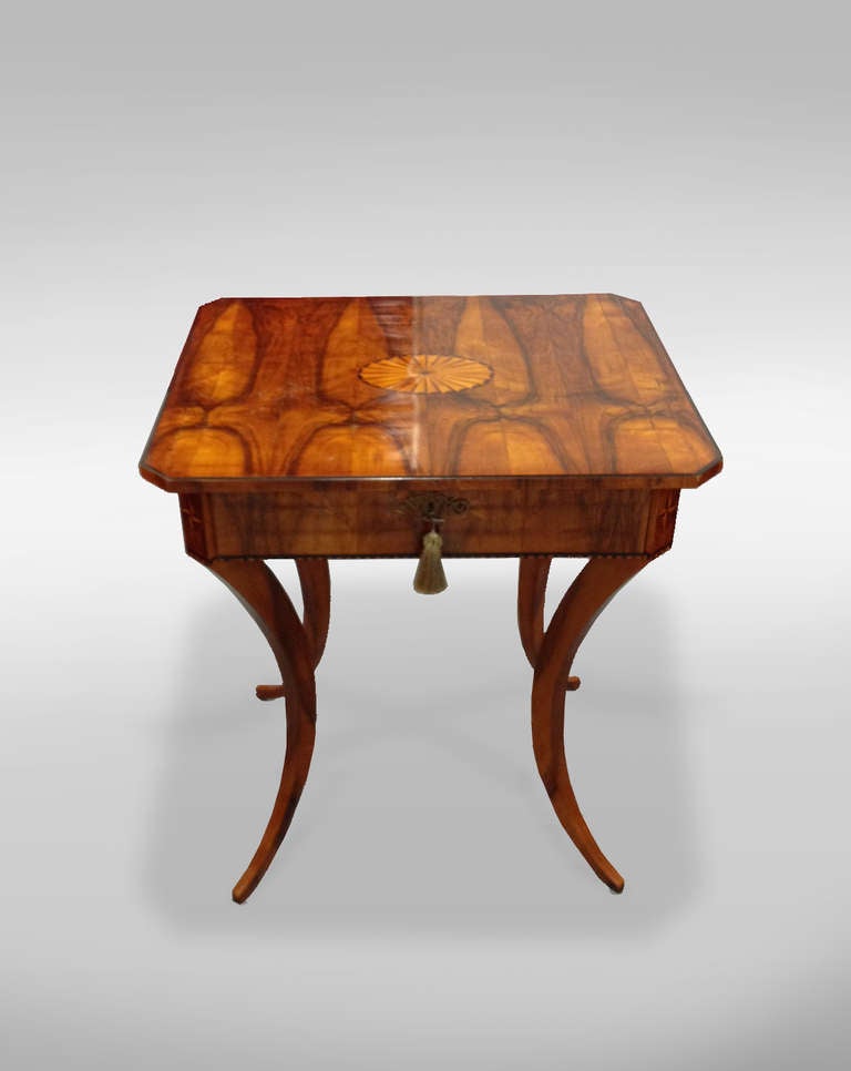 An important example of Vienna design with elegantly tapered saber leg, with vivid book matched walnut veneer and maple inlays and marquetry with a fitted interior drawer. 