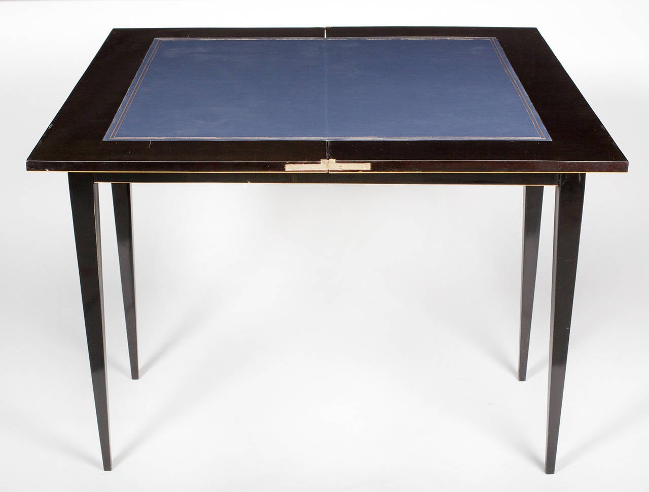 A Biedermeier console or game table in ebonized pear veneer with maple inlays and tapered legs.