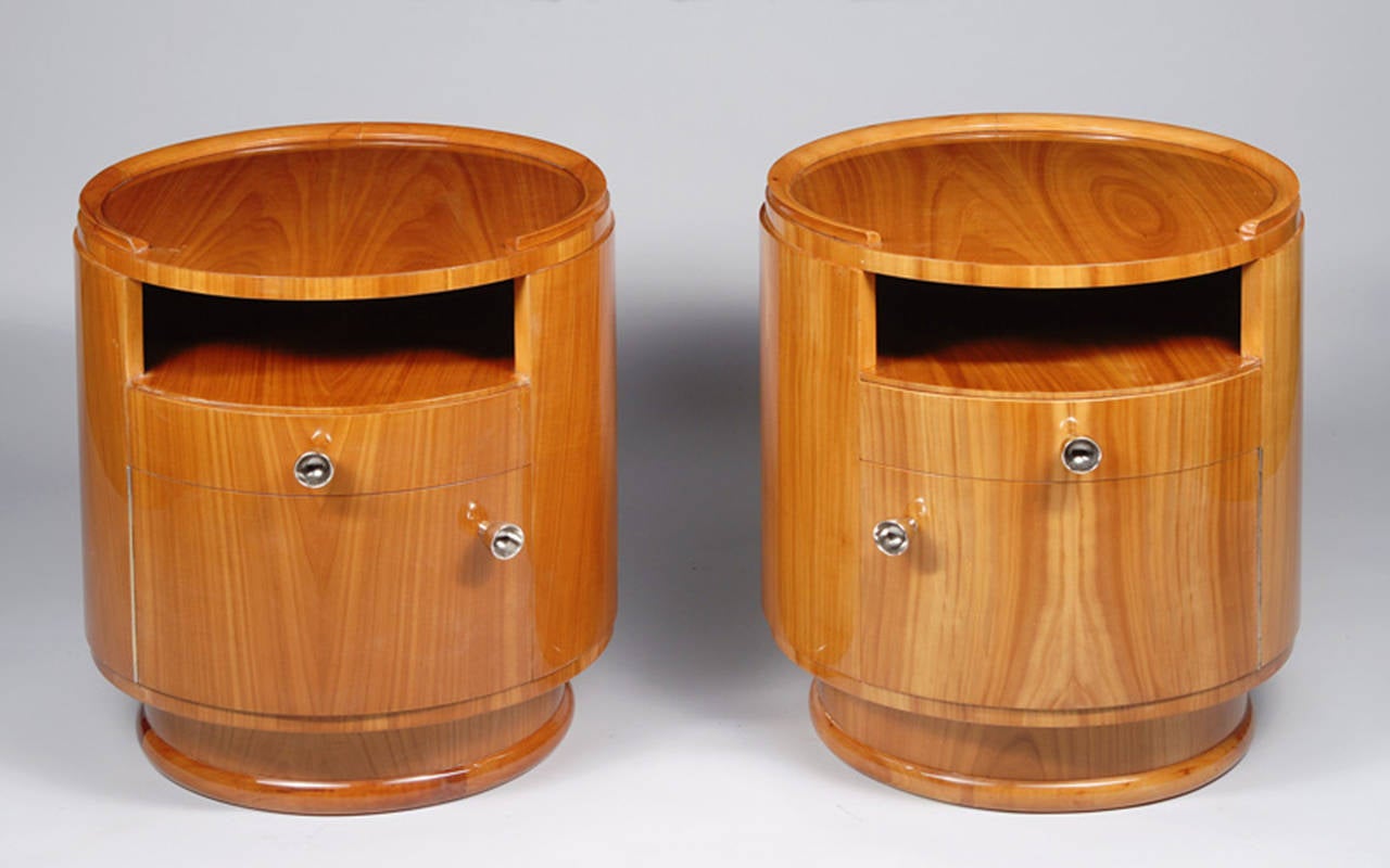 A Pair of Art Deco end tables in cherry veneer with brass pulls and inset glass top.