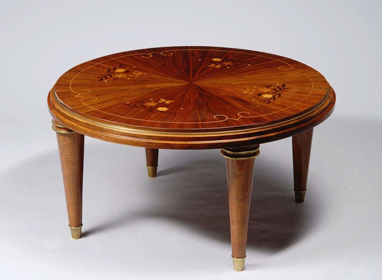 A coffee table in the manner of Jules Leleu with walnut, beechwood, fruitwood and mother-of-pearl inlays and brass sabots.
