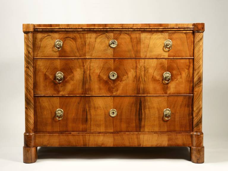 A handsome three-drawer chest in bookmatched walnut veneer with engaged Doric columns.