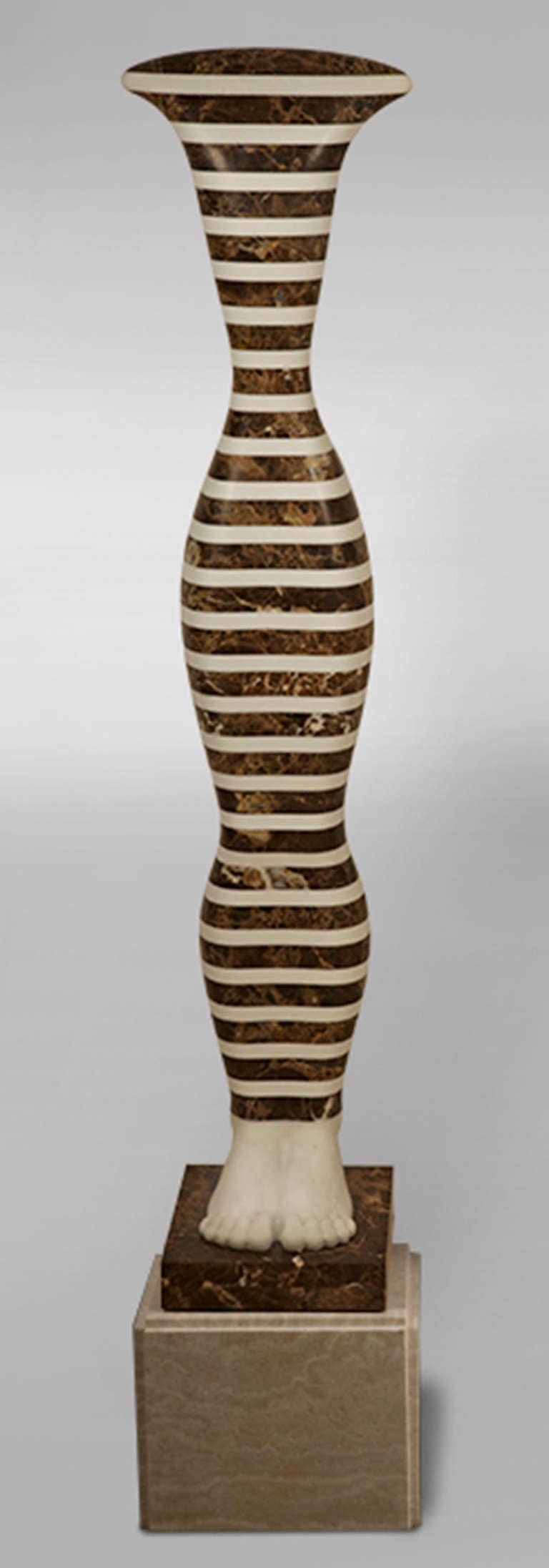 Striped Kouros, 2012 by Laszlo Taubert (Hungarian, b. 1966).
In alternating slabs of cut-and-polished white Portuguese marble and brown limestone. Comes with limestone pedestal (overall height: 65.5 inches).
Measures: 57.0" H x 12.5" W x