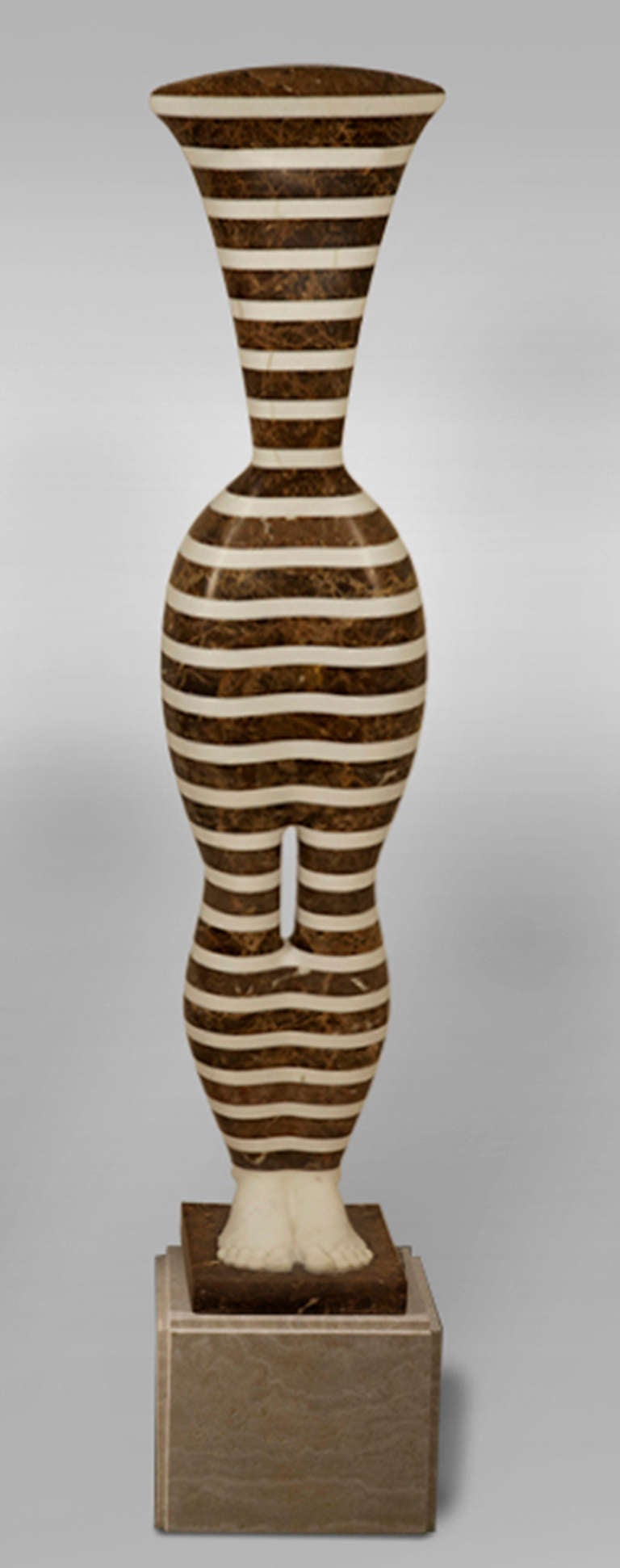 Striped Kore, 2012 by Laszlo Taubert (Hungarian, b. 1966).
in alternating slabs of cut-and-polished white Portuguese marble and brown limestone. Comes with limestone pedestal (overall height: 65.5 inches)
Measures: 55.5" H x 12.0" W x