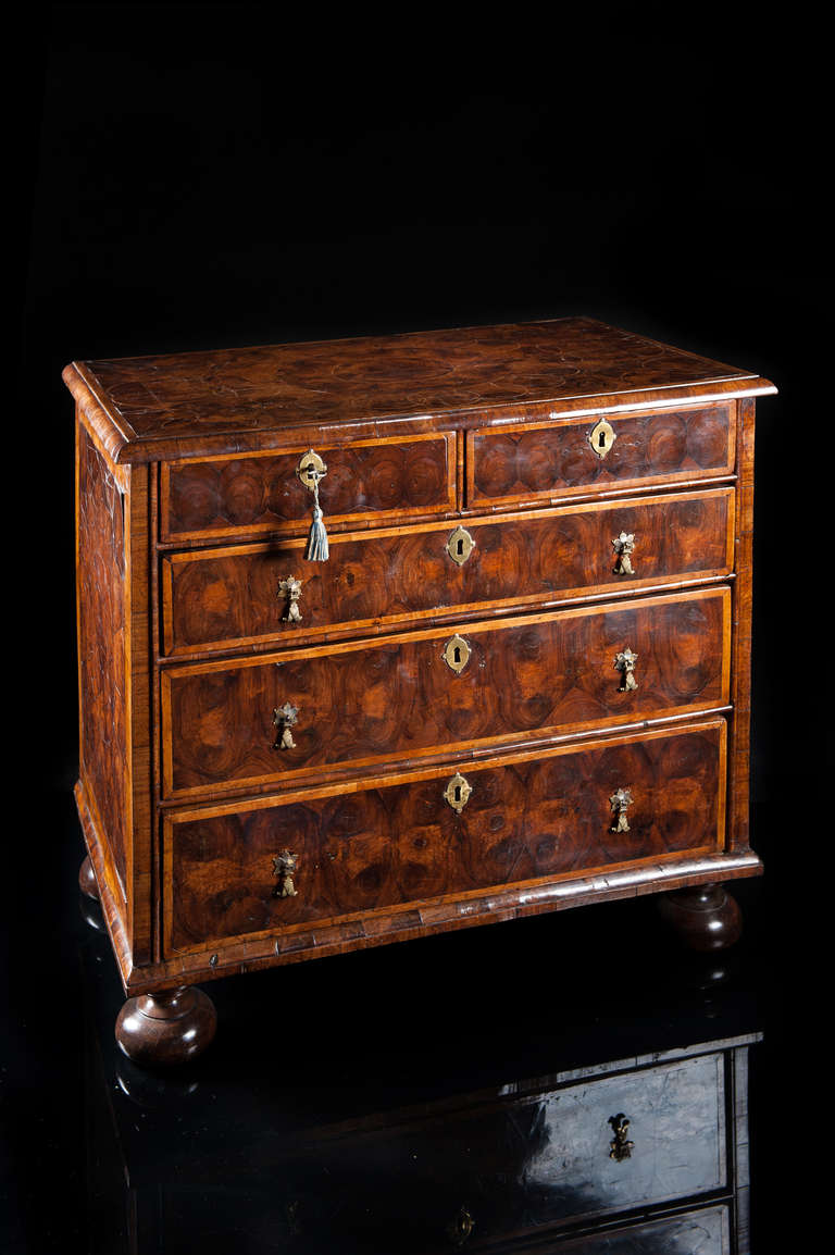 William & Mary oyster veneered five drawer chest of excellent compact proportions. The rectangular top laid with a central circular geometric pattern of cut oyster veneers bordered with inlaid boxwood stringing, with a heart shaped pattern to each
