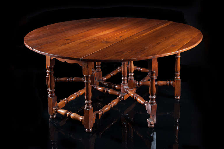A rare 19th century Yew tree eight-seat gate leg table with a circular drop leaf figured top. The lower section with shaped frieze supported on double gates with turned baluster and block turned stretchers. Once the table is turned upside down you