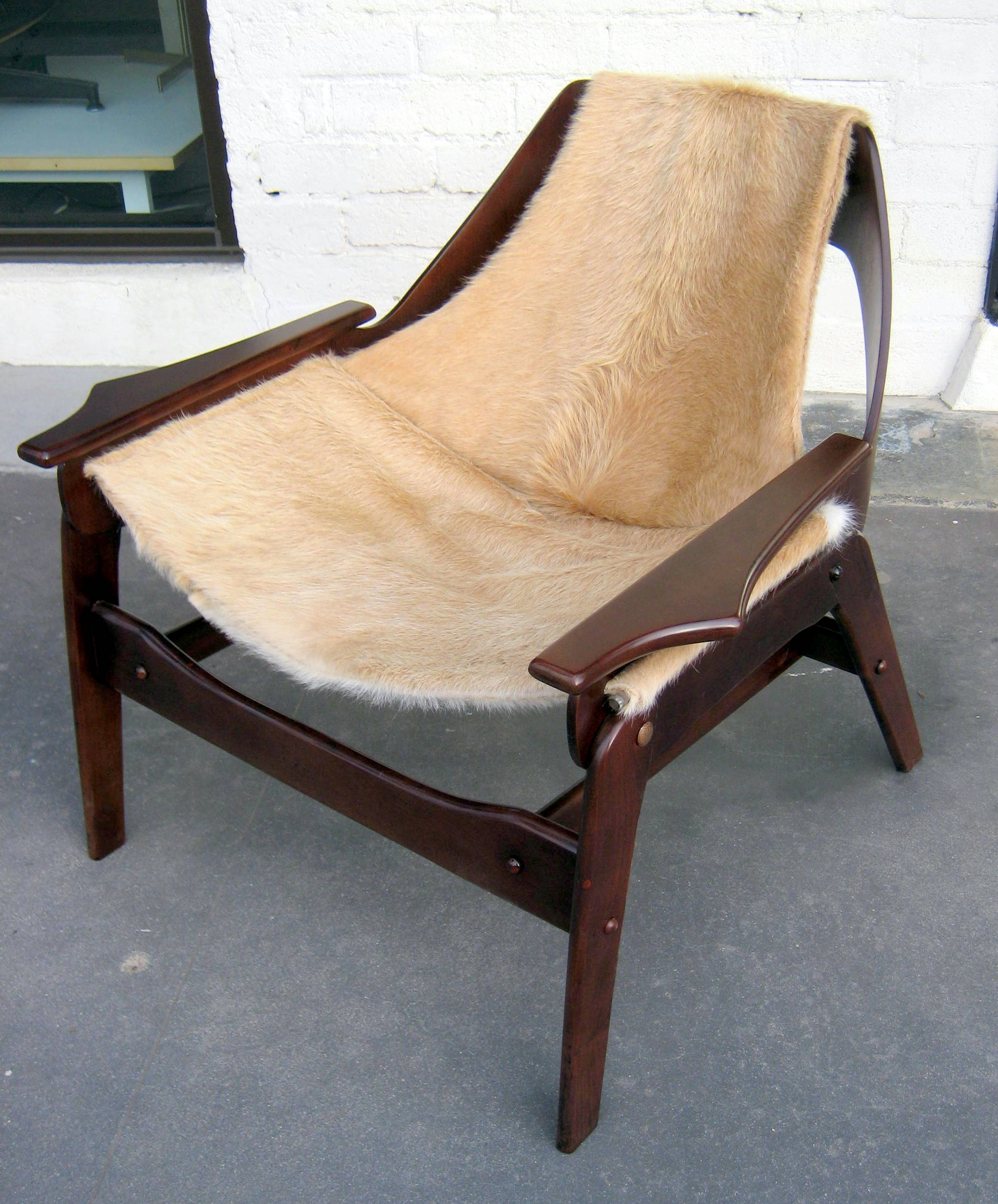 A stained walnut sling chair designed by Jerry Johnson in 1964