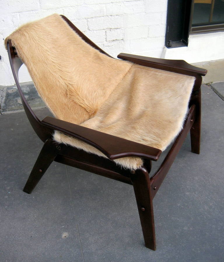 A vintage sling chair designed by Jerry Johnson in 1964. New cowhide upholstery prepared from a pattern made from the original sling seat leather. The cowhide is held in place using the original acrylic dowels on the upper back and under the arm
