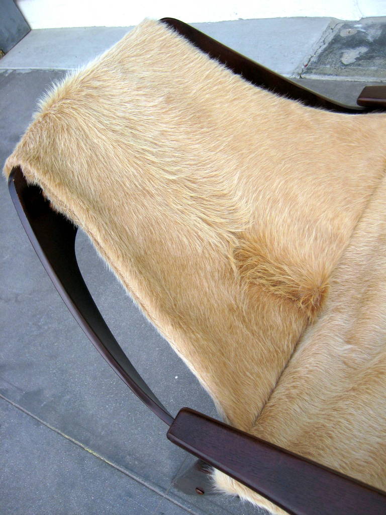 Cowhide A stained walnut sling chair designed by Jerry Johnson in 1964