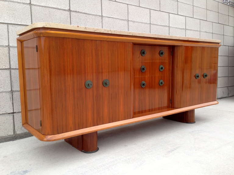 A rare and spectacular mid-20th century French buffet in European walnut with a beige marble top by noted French female designer Suzanne Guiguichon (1900-1985). This tour de force retains its original discrete 1 1/4