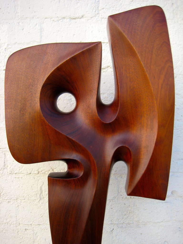 A seductively and very beautifully carved 1970's mahogany sculpture on travertine base. The signature  or 