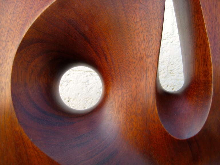 A Seductively Carved 1970's Mahogany Sculpture On Travertine Base. In Excellent Condition In Palm Springs, CA