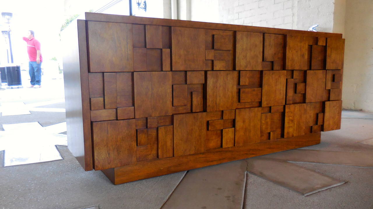 A beautiful and striking cubist inspired nine-drawer walnut chest made by Lane Furniture Company in the 1960s. This beautifully scaled chest has been newly restored in a dark honey color that highlights the strong grain patterns in the walnut.