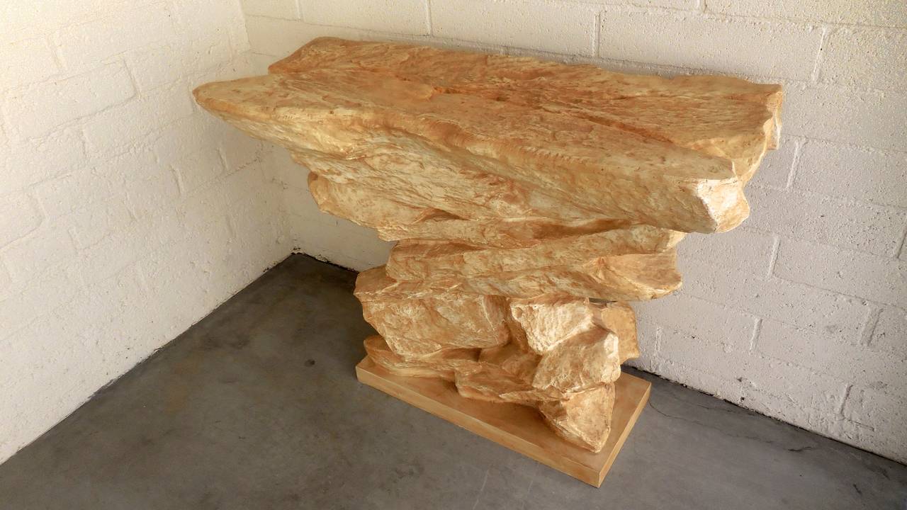 A naturalistic stacked rock-form console table, in the manner of Emilio Terry and attributed to Sirmos, circa 1970s. The table was fabricated from fortified plaster on a wooden base and retains an old paint finish. The console is shown and sold