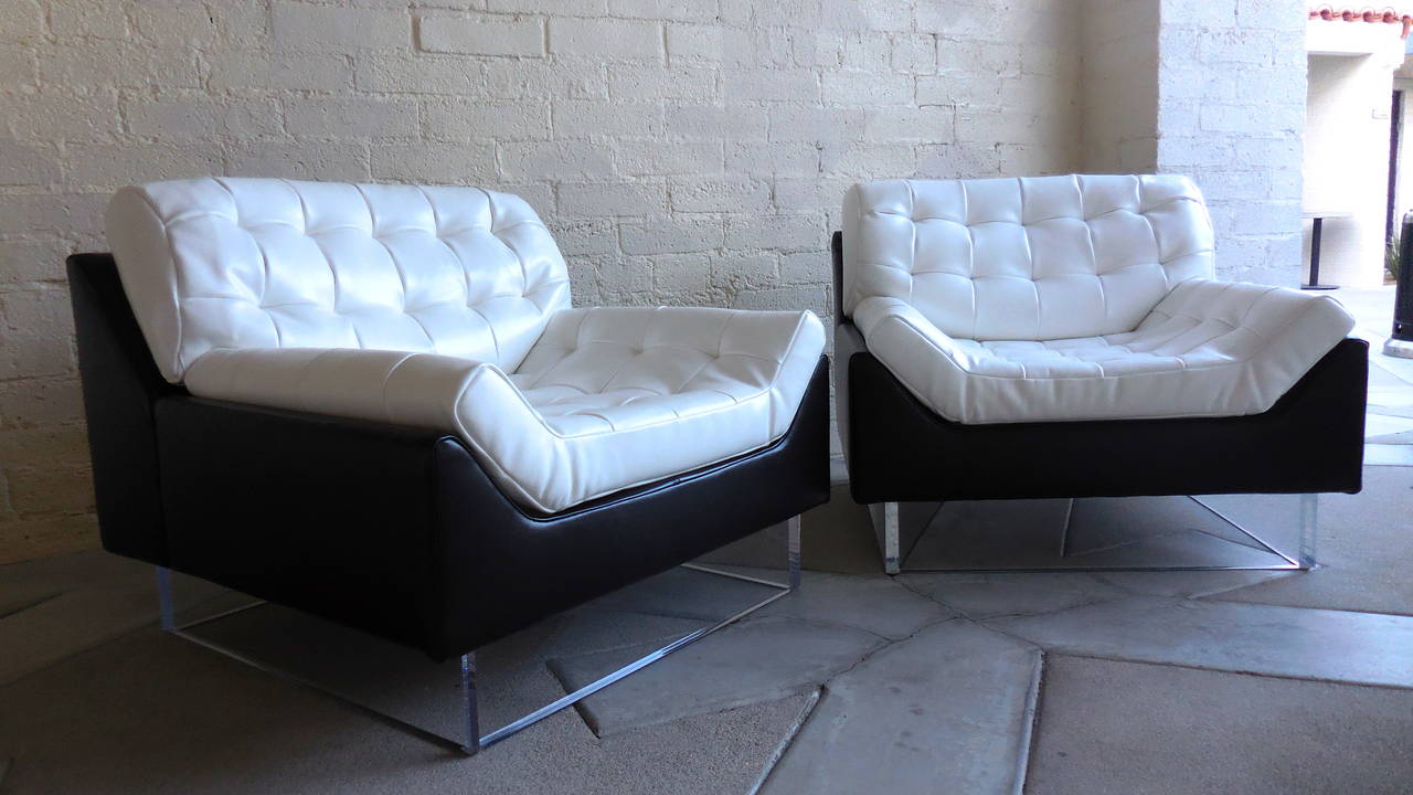 A fabulous pair of 1970s club chairs. This duo is newly reupholstered in hand selected black and white leather. The tops have been assembled from cut squares of white leather stitched into a larger section and then stitch tufted.
This textured