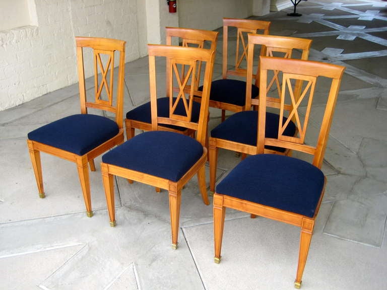 A gorgeous set of six 1950s, French neoclassical cherrywood dining chairs with gilded brass sabot feet. The set has recently been reupholstered in a blue low-pile looped fabric.