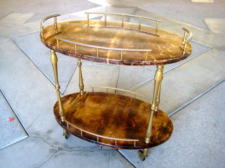 A diminutive goat skin/vellum drinks trolley/side table designed by Aldo Tura in Milan, Italy. Circa 1950's. The fittings and galleries are all fabricated out of antiqued gilded brass and the secondary wood is mahogany. The vellum has a deep rich