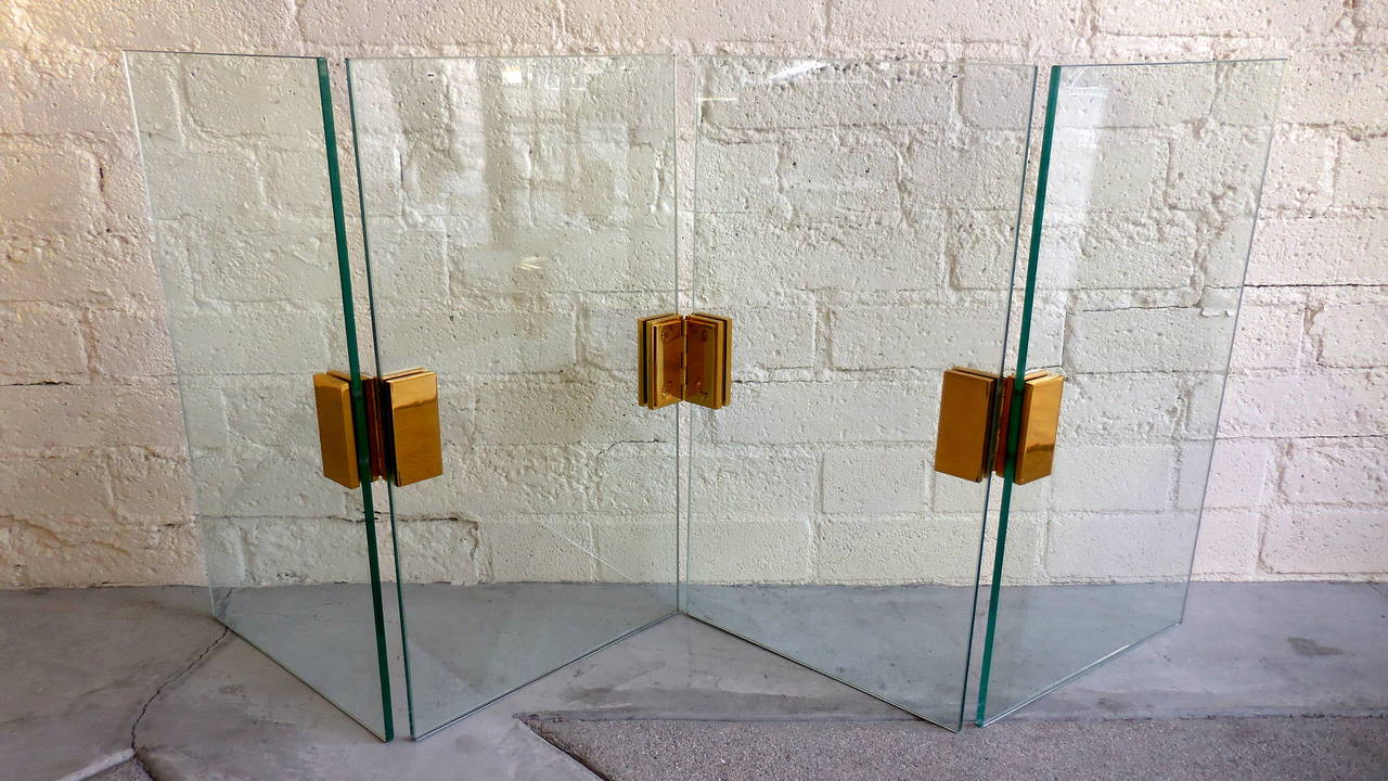 A heavy duty tempered glass four-panel folding fire screen with solid brass hinges made in the 1980s. Similar in design to items made by pace, this screen does not bear any maker marks and presents a sleek design for any fireplace. Each of the glass