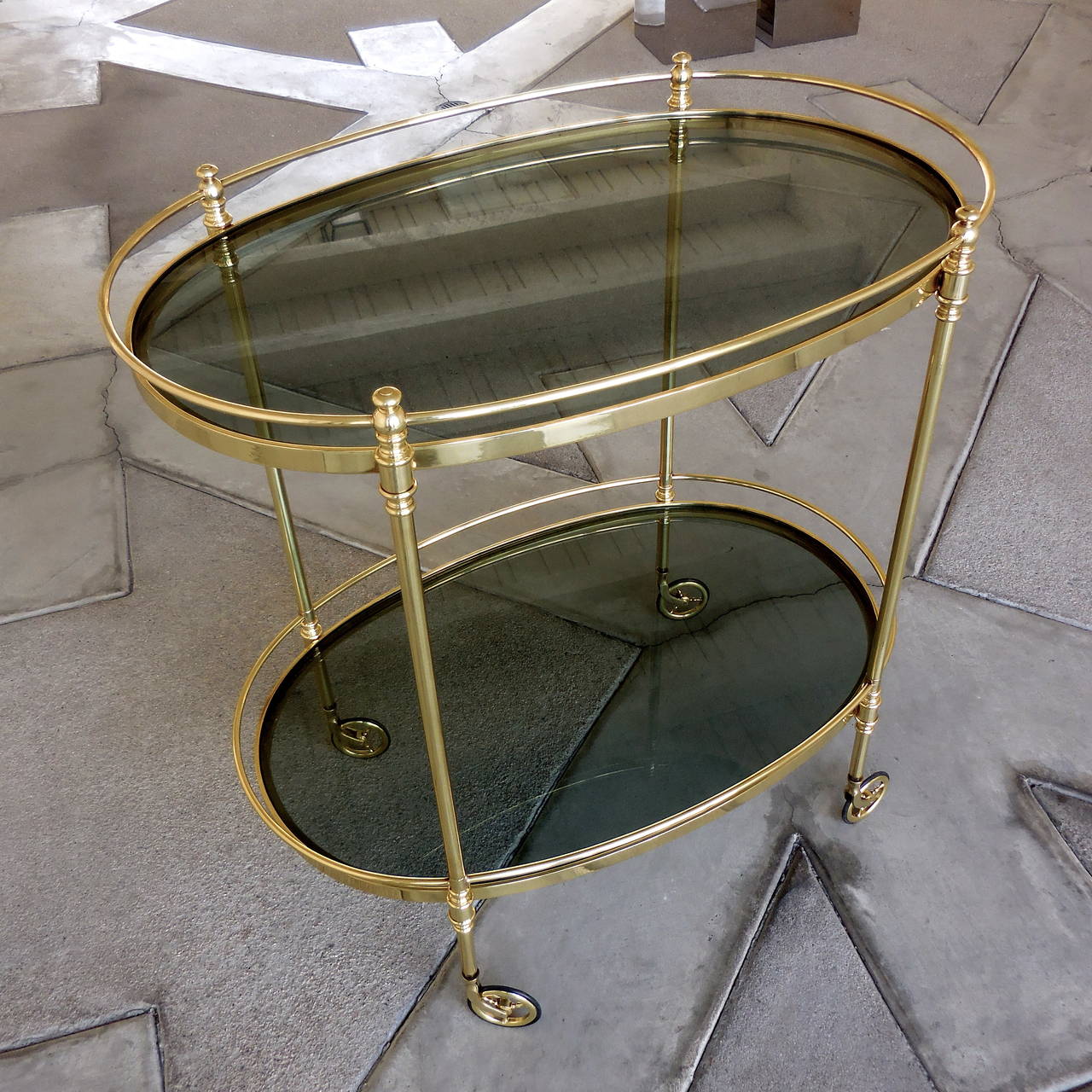 A fine quality solid brass two-tier oval serving cart with smoked glass shelves made in the 1950s. The cart does not bear any maker's marks but is similar in form to pieces made in Italy during this period, specifically in the wheel design.
The