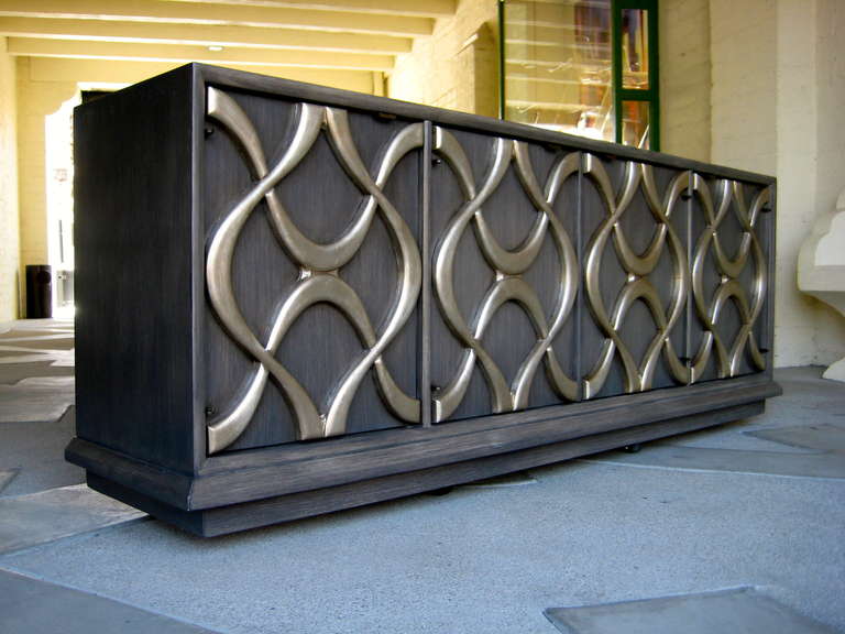 A 1970's sculpted facade credenza with a dry brush grey and silver leaf raised arabesque carved wood detail. Manufactured by Stanley. Newly refinished and restored.