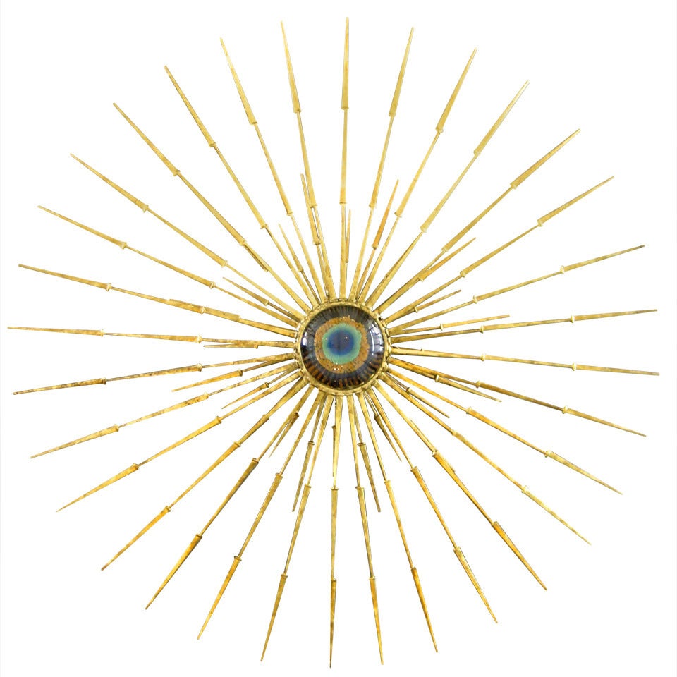 A radiant gold leafed wall sculpture with vintage Murano glass eye in the center by Del Williams