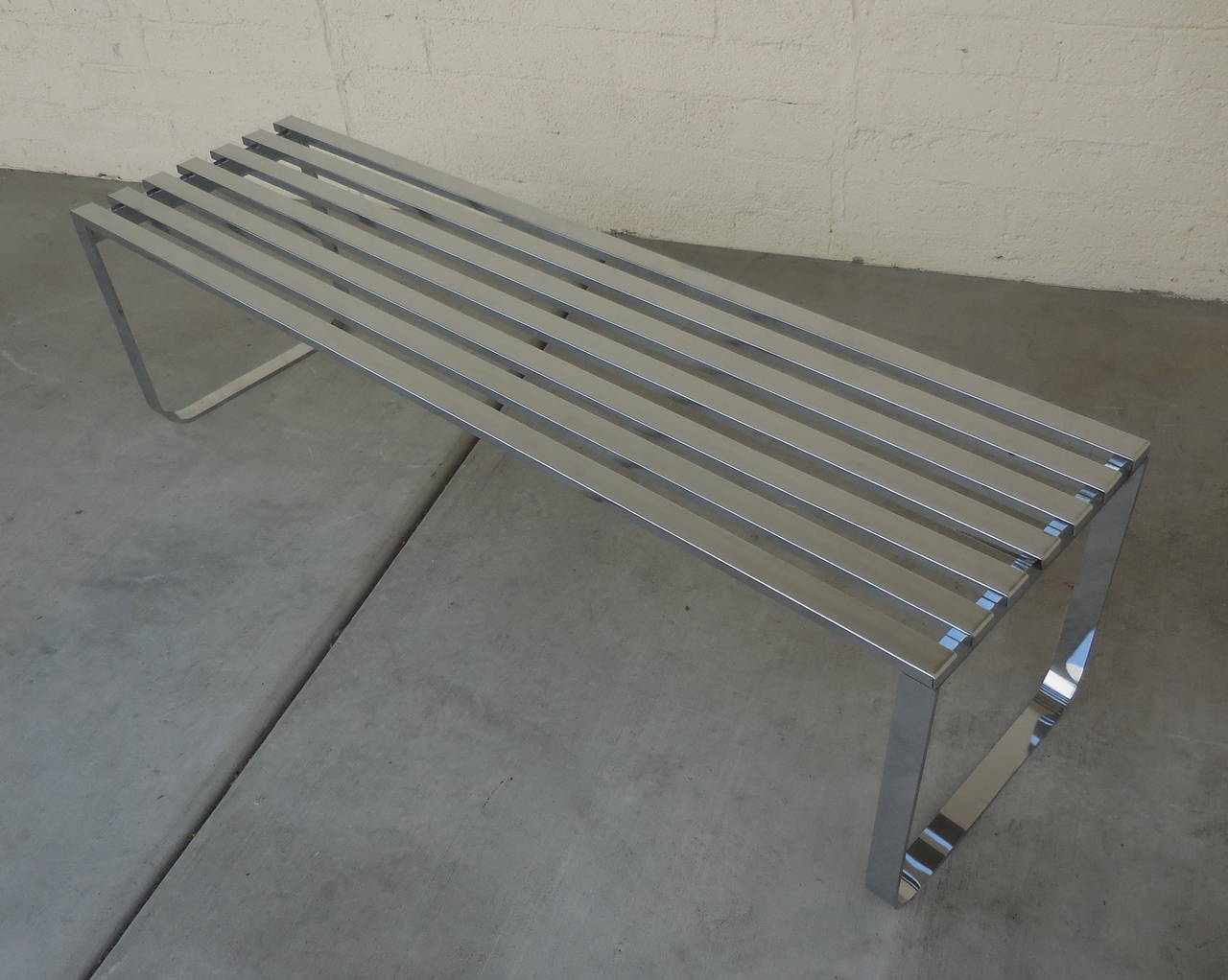 A long chrome-plated steel slatted bench designed by Milo Baughman from the 1970s. This bench can also be used as a coffee table and is the perfect size to,
sit at the foot of a bed.